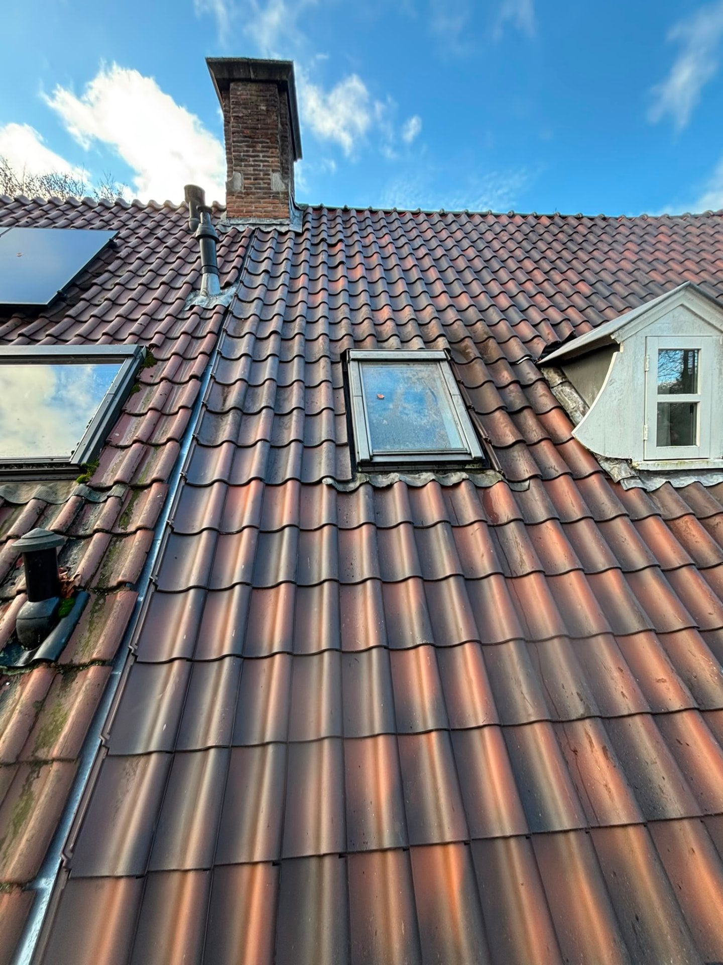 Pannendak met schoorsteen, dakraam en dakkapel, beoordeeld tijdens een dakinspectie